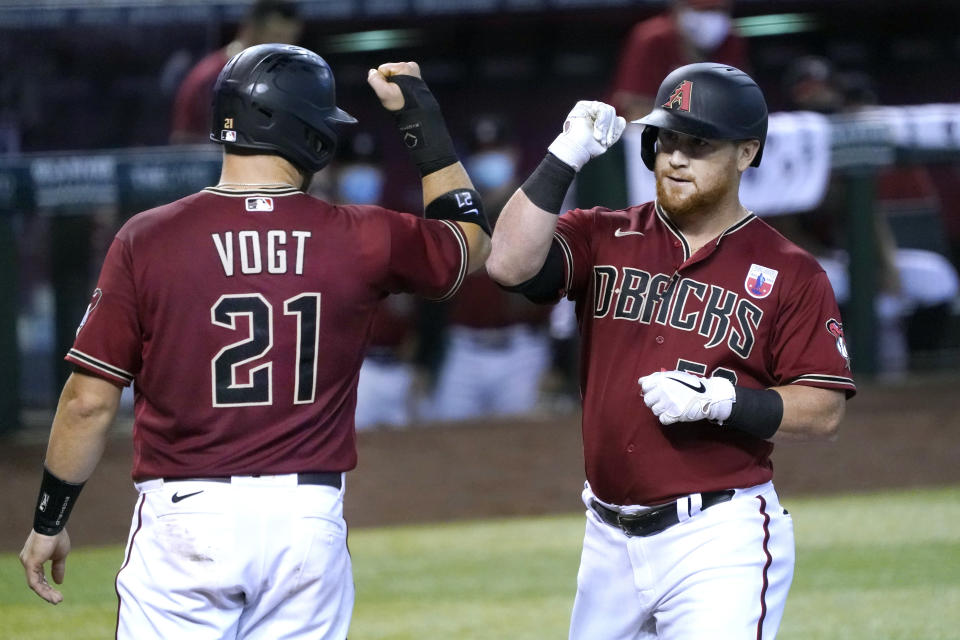 Arizona Diamondbacks' Kole Calhoun celebrates with Stephen Vogt (21) after hitting a two-run home run against the San Diego Padres in the third inning during a baseball game, Sunday, Aug 16, 2020, in Phoenix. (AP Photo/Rick Scuteri)