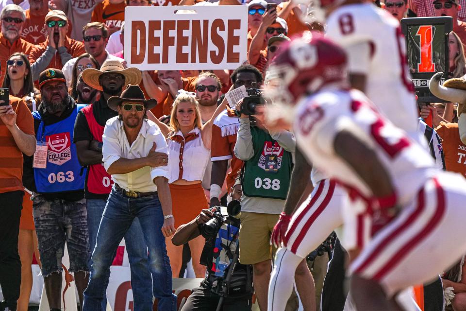 Actor Matthew McConaughey watches from the UT sideline in front of a cheerleader imploring for defense. The Sooners produced 486 yards of total offense, balanced between 285 passing and 201 rushing yards.