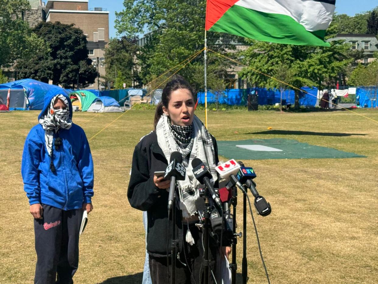 Kalliopé Anvar McCall, a fourth-year U of T student in diaspora studies, speaks at a news conference at the King’s College Circle encampment on Friday, May 24, 2024. She called the school’s negotiations ‘a joke.’   (Chris Glover/CBC  - image credit)