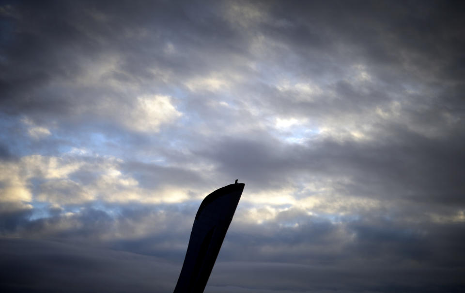 A worker stands atop the Olympic cauldron at the 2014 Winter Olympics, Saturday, Feb. 1, 2014, in Sochi, Russia. (AP Photo/David Goldman)