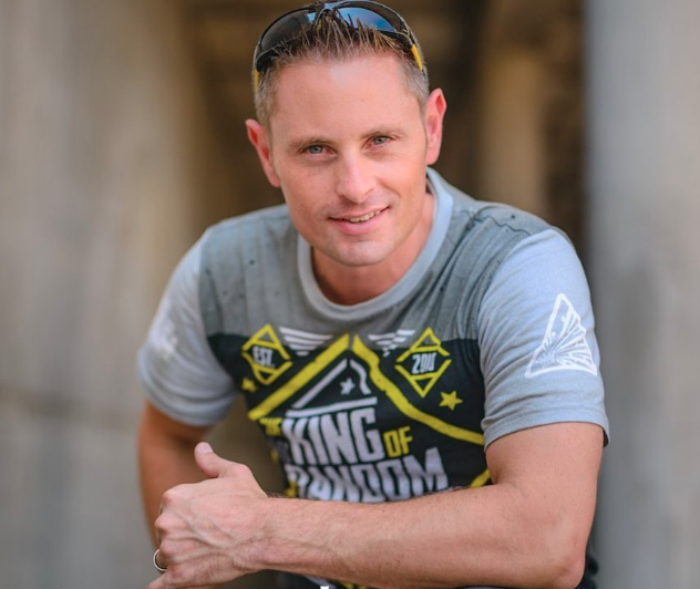 Grant Thompson kneels down as he wears a The King of Random t-shirt promoting his YouTube channel. 