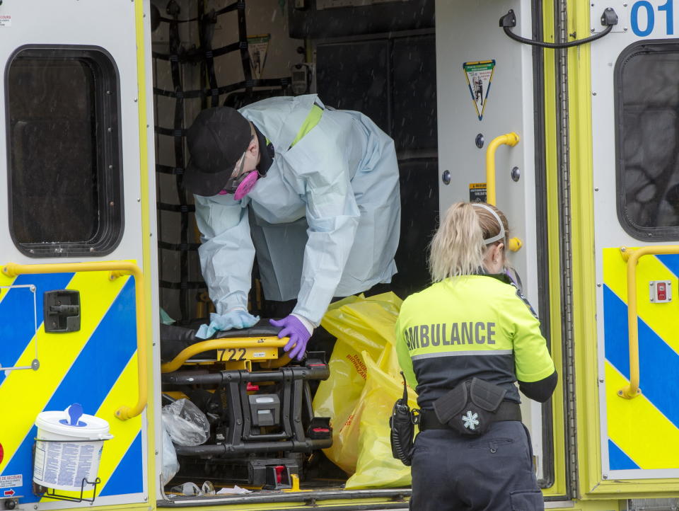 First responders sanitize their ambulance after transporting a patient to the Verdun Hospital, Thursday, April 2, 2020 in Montreal. The hospital has seen a sharp spike in the number of COVID-19 cases among patients and staff. (Ryan Remiorz/The Canadian Press via AP)