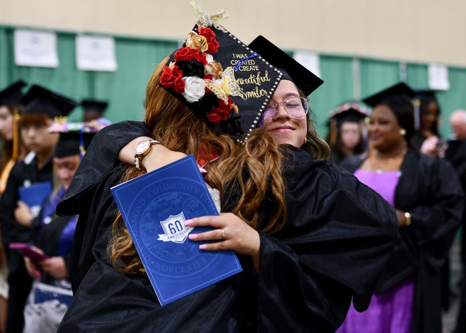 Sherline Clemente of Worcester hugs Beniada Variste of Worcester during Quinsigamond Community College commencement exercises at the DCU Center on Friday.
