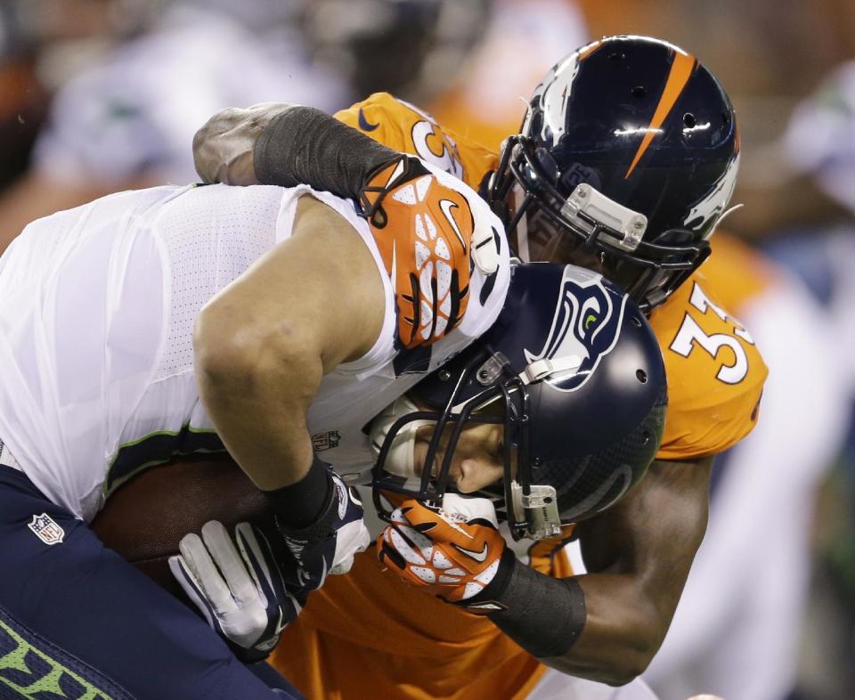 Seattle Seahawks' Jermaine Kearse, left, is tackled by Denver Broncos' Duke Ihenacho, right, during the first half of the NFL Super Bowl XLVIII football game Sunday, Feb. 2, 2014, in East Rutherford, N.J. (AP Photo/Jeff Roberson)