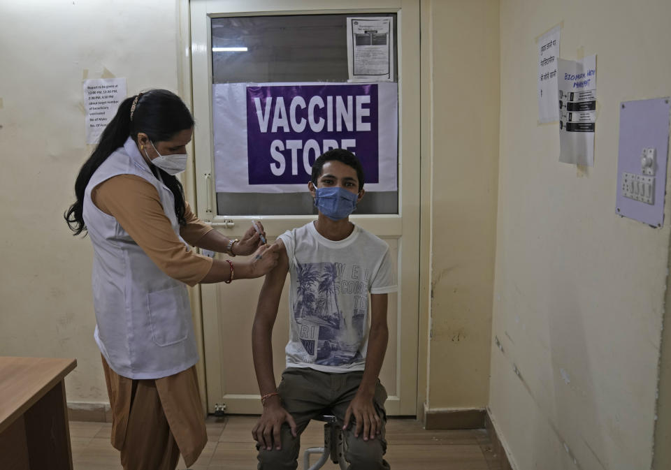 A health worker administers the vaccine for COVID-19 at a vaccination center in New Delhi, India, Tuesday, Sept. 21, 2021. India, the world's largest vaccine producer, will resume exports and donations of surplus coronavirus vaccines in October after halting them during a devastating surge in domestic infections in April, the health minister said Monday. (AP Photo/Manish Swarup)