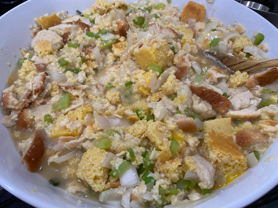 Mixing Paula Deen's stuffing ingredients in white bowl