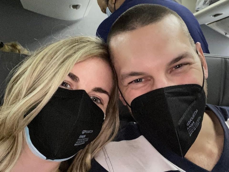 the writer and her husband wearing black masks on a plane