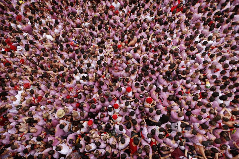 <p>Revelers pack the town hall square during the launch of the ‘Chupinazo’ rocket to celebrate the official opening of the 2014 San Fermin fiestas, in Pamplona, Spain, July 6, 2014. (Photo: Daniel Ochoa de Olza/AP) </p>