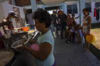 Residents whose homes became inhabitable due to Hurricane Ian get a hot meal at a school-turned-shelter in La Coloma, in Pinar del Rio province, Cuba, Wednesday, Oct. 5, 2022. (AP Photo/Ramon Espinosa)