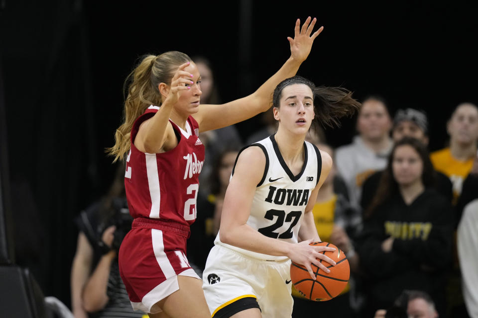 Iowa guard Caitlin Clark passes around Nebraska forward Natalie Potts, left, during the first half of an NCAA college basketball game, Saturday, Jan. 27, 2024, in Iowa City, Iowa. (AP Photo/Charlie Neibergall)