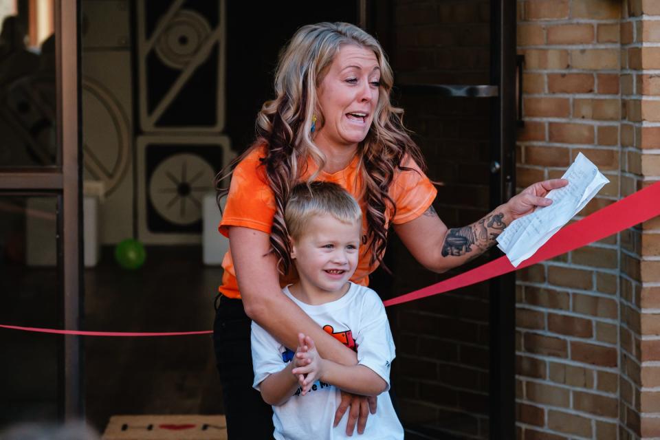 Lacey Herbert-Stephen, CEO and founder of the Adaptive Movement Center embraces her son Cash, 4, who is autistic, during a celebration of the newly opened facility in downtown New Philadelphia.