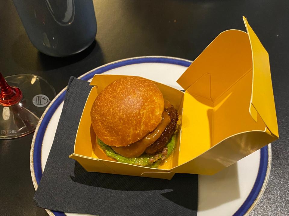 a burger in a yellow cardboard box on a plate at  Franceschetta58