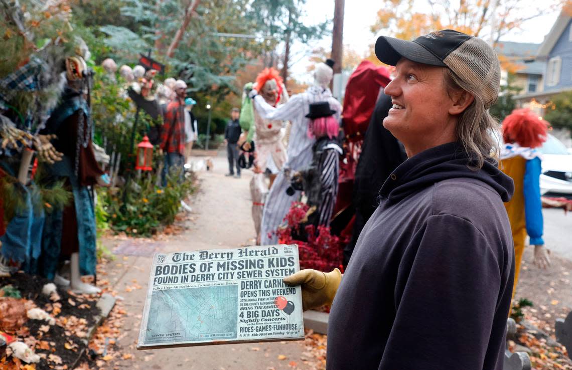 Jesse Jones tries to figure out where to place a sign outside his Oakwood home Friday, Oct. 28, 2022. Jones has more than 50 full-sized monsters set up in his yard bringing thousands of visitors on Halloween.
