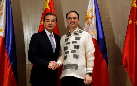 Philippine Foreign Affairs Secretary Alan Peter Cayetano (R) shakes hands with China's Foreign Minister Wang Yi in Taguig, Metro Manila, Philippines July 25, 2017. REUTERS/Erik De Castro