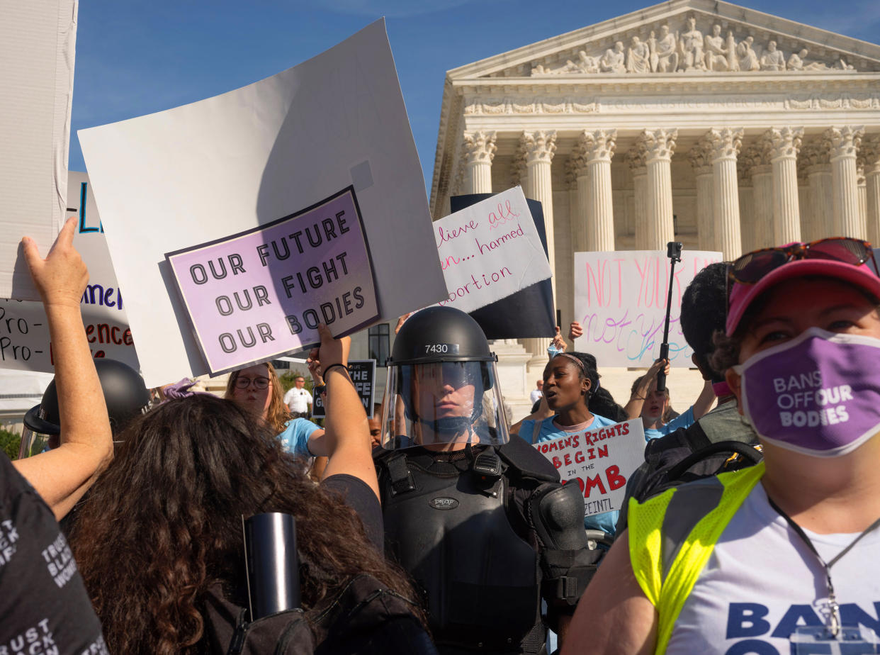 Protesters and counter-protestors meet outside of the Supreme Court at the Women's March and Rally for Abortion Justice in Washington, DC, on October 2, 2021.  Counter-protestors are behind the gates on the side of the Supreme Court, protected by a swat team and police officers.