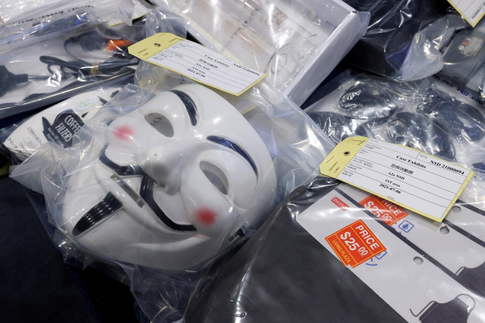 A Guy Fawkes mask is placed with evidence displayed during a news conference after police’s National Security Department arrested nine people they said are suspected of terrorist activities, in Hong Kong, China July 6, 2021. REUTERS/Tyrone Siu