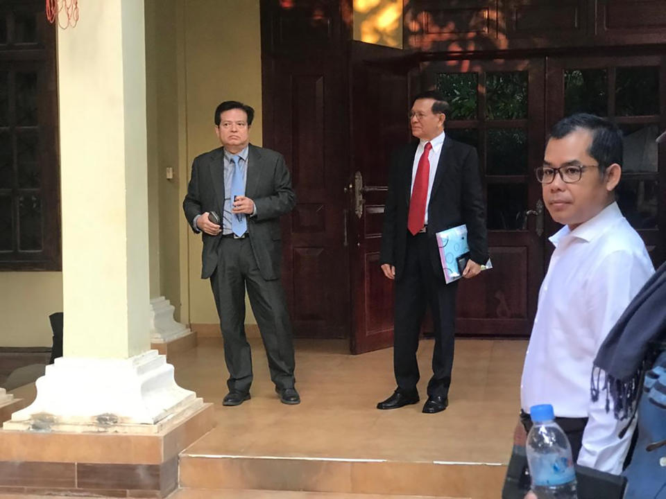 Cambodian opposition leader Kem Sokha, center, waits before he heads to the court in his home, in Phnom Penh, Cambodia, Wednesday, Jan. 15, 2020. The trial of the top opposition leader charged with treason began Wednesday, more than two years after he was arrested in what is widely seen as a politically motivated prosecution. (AP Photo/Cheang Sopheng)