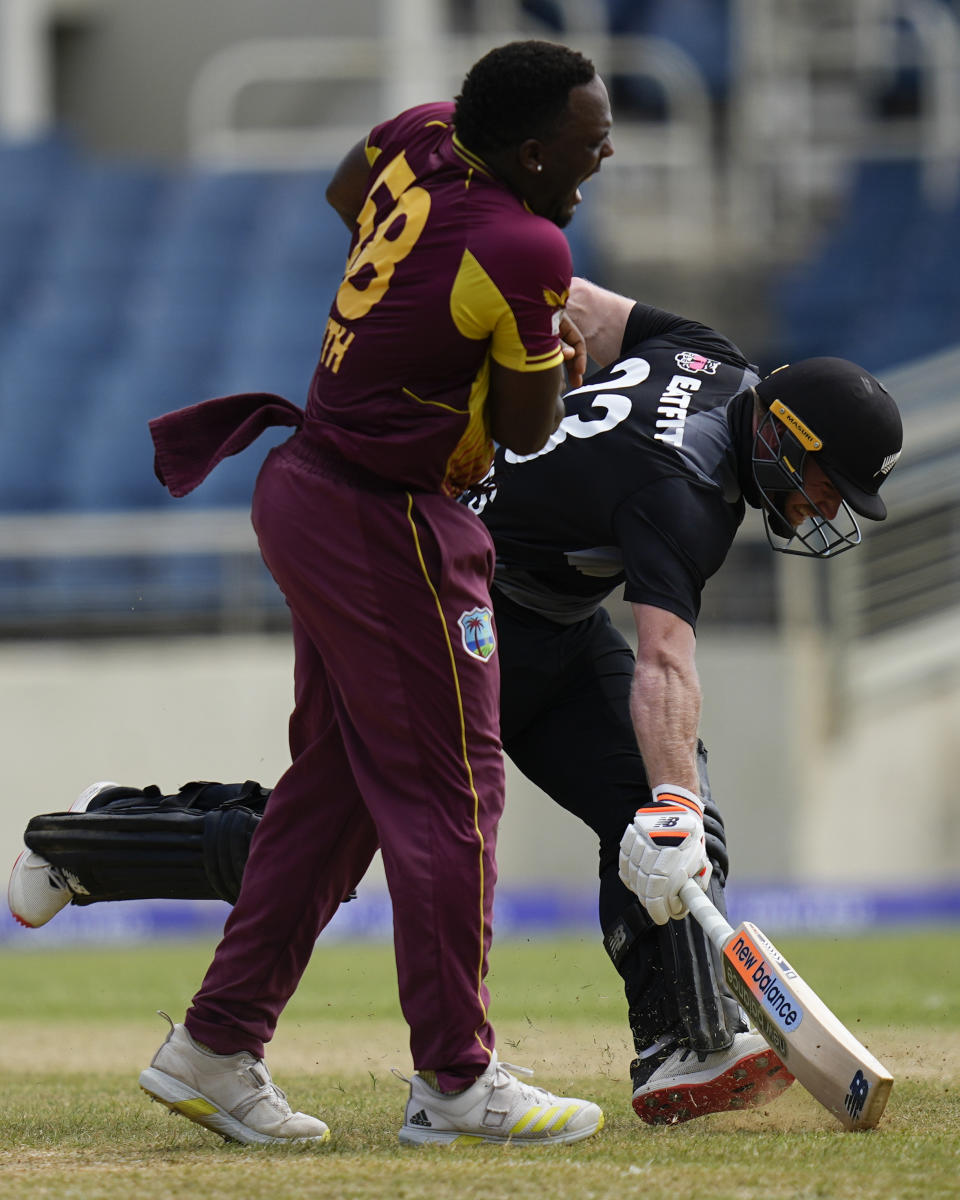 New Zealand's Glenn Phillips safely makes it to the crease challenged by West Indies' Odean Smith during the third T20 cricket match at Sabina Park in Kingston, Jamaica, Sunday, Aug. 14, 2022. (AP Photo/Ramon Espinosa)
