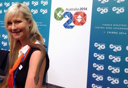 An official guide displays a native Australian snake around her shoulders at the venue of the G20 Finance Ministers and Central Bank Governors Meeting in Cairns September 19, 2014. REUTERS/Lincoln Feast