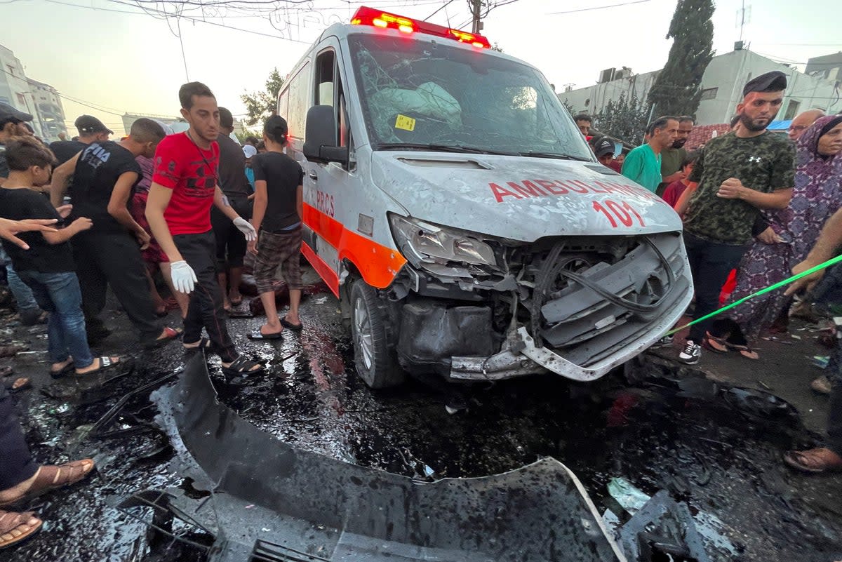 Palestinians help the victims of an Israeli airstrike that hit an ambulance on Friday (Reuters)