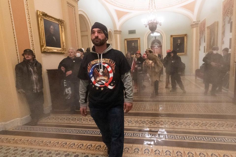 Smoke fills the walkway outside the Senate Chamber as supporters of President Donald Trump are confronted by U.S. Capitol Police officers inside the Capitol (AP)