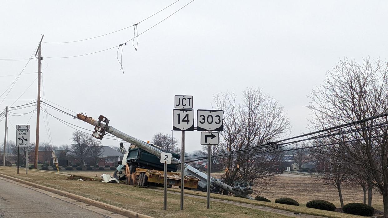 A dump truck struck a utility pole, shearing it off and damaging transformers, at the side of state Route 303 at Market Square Drive in Streetsboro Tuesday morning. Power outages in the area were blamed on the crash that occurred after a minivan went through a red light at the intersection.