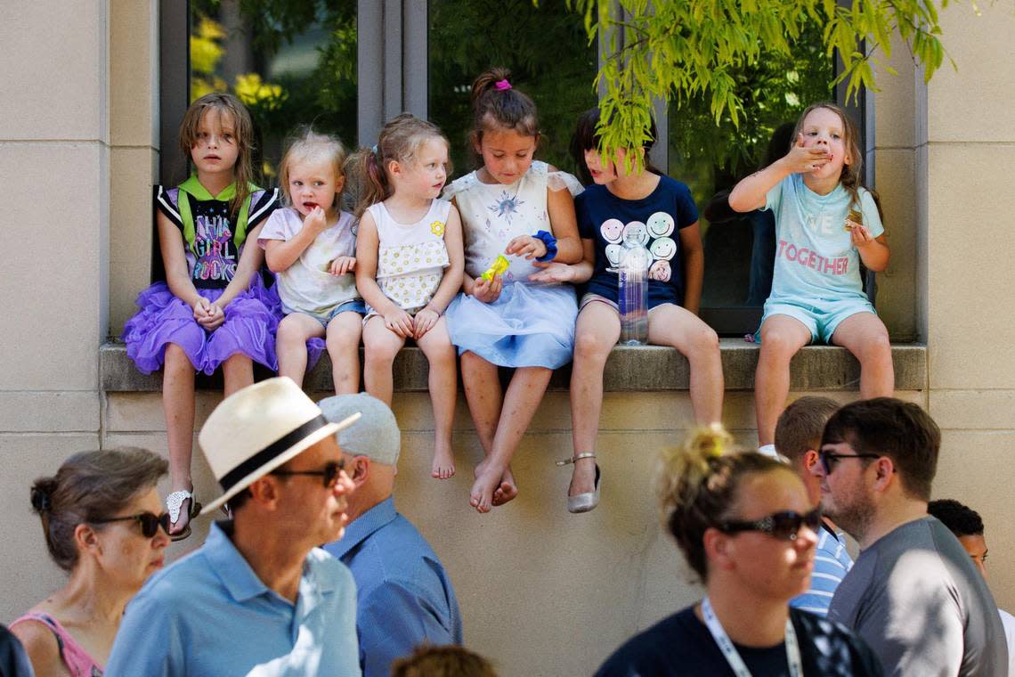 A group of children watch and eat snacks during the City of Lexington’s Fourth of July celebration parade on Monday, July 4, 2022, on Main Street in Lexington, Kentucky.