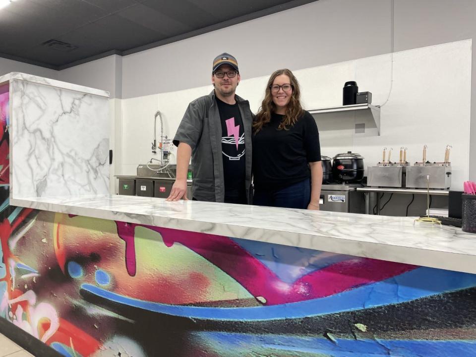 Mark Skelton and Emily Underwood stand behind the counter at Electric Ramen in March 2022.