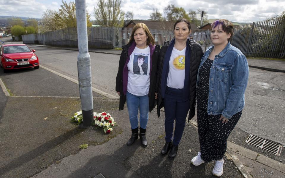 (From left) Lyra McKee's sisters Nichola Corner and Joan Hunter and Lyra's partner Sara Canning stand together after friends and family laid wreaths at the spot where Lyra McKee was shot