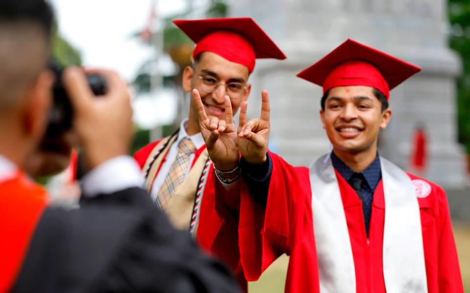 N.C. State seniors Jay Patel, left, and Dev Sutariya get their photo taken by Niraj Lavani at the Memorial Belltower in Raleigh, N.C., Saturday, April 29, 2023.