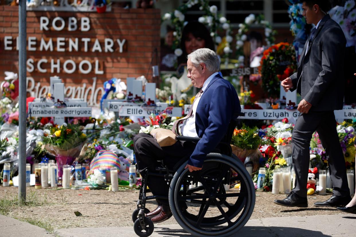 Texas Gov. Greg Abbott passes in front of a memorial outside Robb Elementary School to honor the victims killed in a school shooting in Uvalde, Texas, May 29, 2022. 