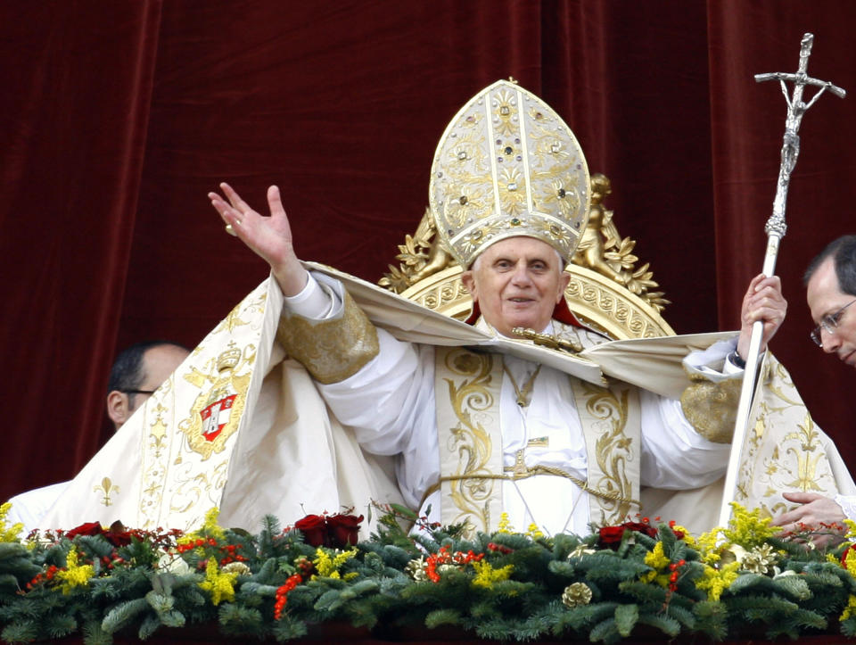 FILE - Pope Benedict XVI greets the faithful to deliver his "Urbi et Orbi" message, Latin for ''to the city and to the world", as he appears from the velvet-draped central balcony of St. Peter's Basilica at the Vatican, Tuesday, Dec. 25, 2007. (AP Photo/Alessandra Tarantino, File)