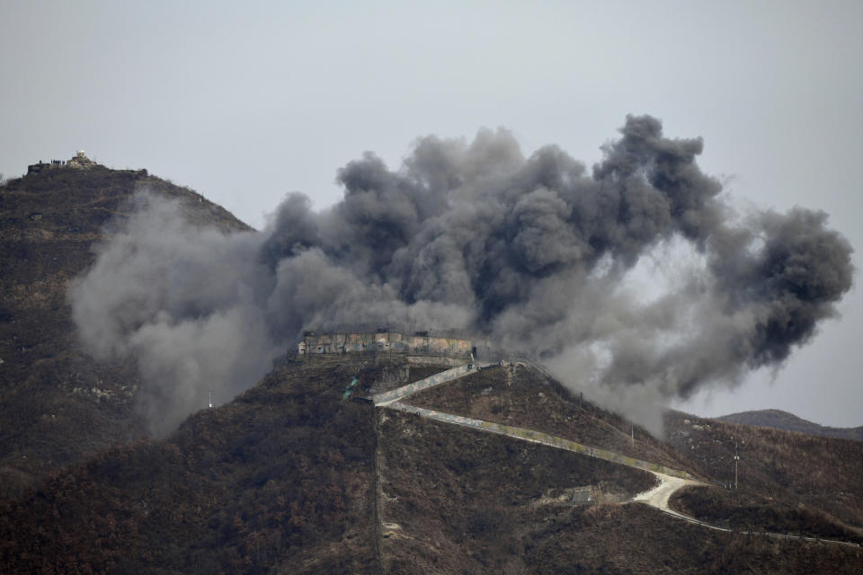 FILE - Smoke from an explosion rises as part of the dismantling of a South Korean guard post in the Demilitarized Zone dividing the two Koreas in Cheorwon, on Nov. 15, 2018 as a North Korean guard post sits high in the upper left. (Jung Yeon-je/Pool Photo via AP, File)