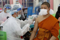 A health worker injects a Buddhist monk with dose of the Sinovac COVID-19 vaccine in Bangkok, Thailand, Monday, April 12, 2021. Thailand's Health Ministry warned Sunday that restrictions may need to be tightened to slow the spread of a fresh coronavirus wave, as the country hit a daily record for new cases. (AP Photo/Sakchai Lalit)