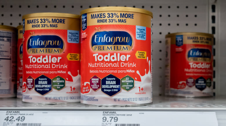 Containers of toddler milk on store shelf
