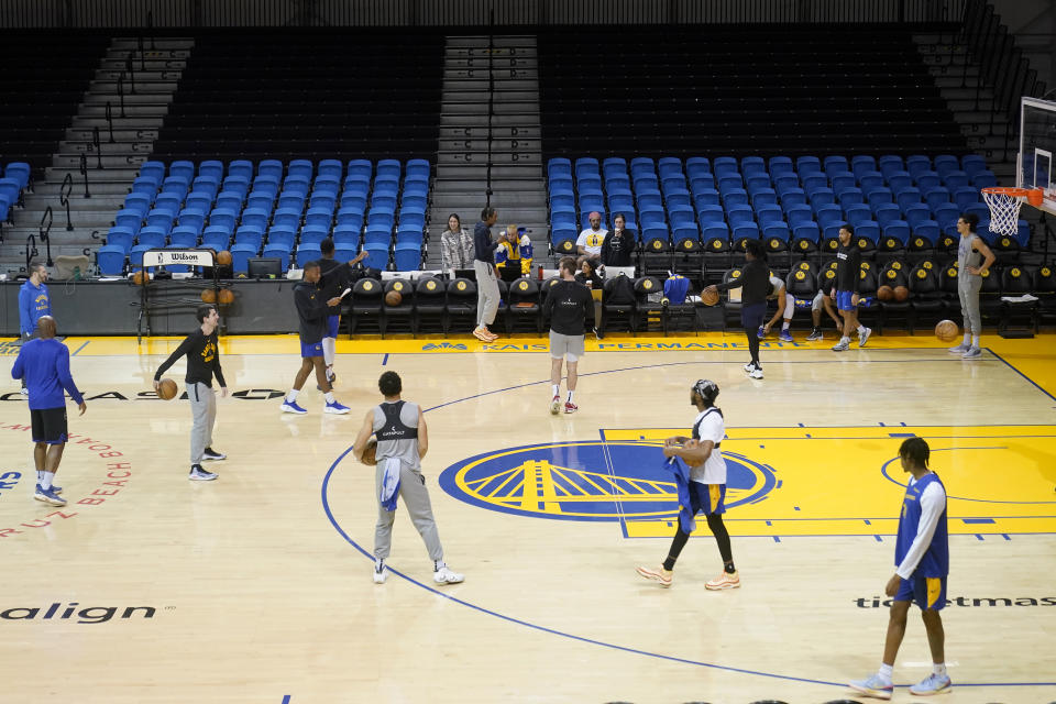 Santa Cruz Warriors coach Nicholas Kerr, third from left, stands on the court during the team's basketball practice in Santa Cruz, Calif., Friday, Jan. 12, 2024. Each day, Kerr strives to find a balance between fun and fire while leading Golden State's developmental G League team minus all the big stars - like Stephen Curry - his famous father, Steve Kerr, gets to work with every day. (AP Photo/Jeff Chiu)