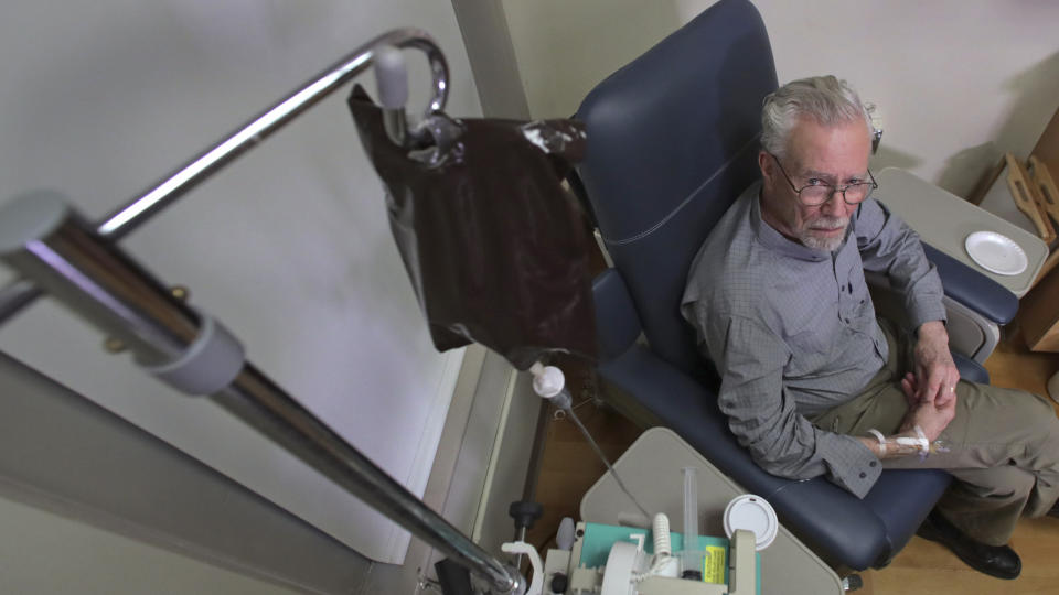 In this Nov. 22, 2019, photo, Charles Flagg, who is stricken with Alzheimer's disease, receives the contents of an intravenous bag while participating in a study on the drug Aducanumab at Butler Hospital in Providence, R.I. New results were released on the experimental medicine whose maker claims it can slow the decline of Alzheimer's disease, the most common form of dementia. (AP Photo/Charles Krupa)