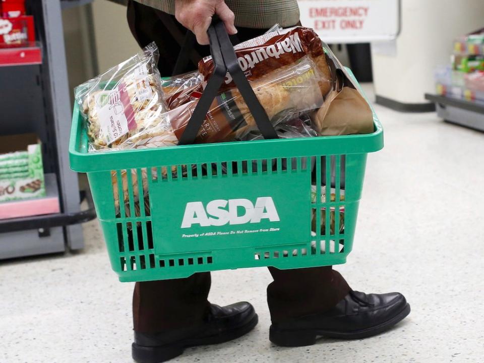 A man carries a shopping basket in an Asda store in northwest London, Britain August 18, 2015. Sales at Wal-Mart's British supermarket Asda fell for a fourth straight quarter on Tuesday, down 4.7 percent to confirm its position as the weakest performer in a sector hammered by the growth of discount retailers.