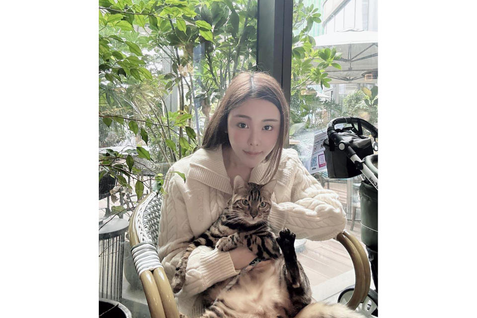 In this photo taken and provided by Pao Jo-yee, model Abby Choi, holding a cat, poses for a photo on Feb. 11, 2023, in Hong Kong. The ex-husband and former in-laws of the slain Hong Kong model were put in custody without bail Monday, Feb. 27, 2023, on a joint murder charge, after police found parts of her body in a refrigerator.(Pao Jo-yee via AP)