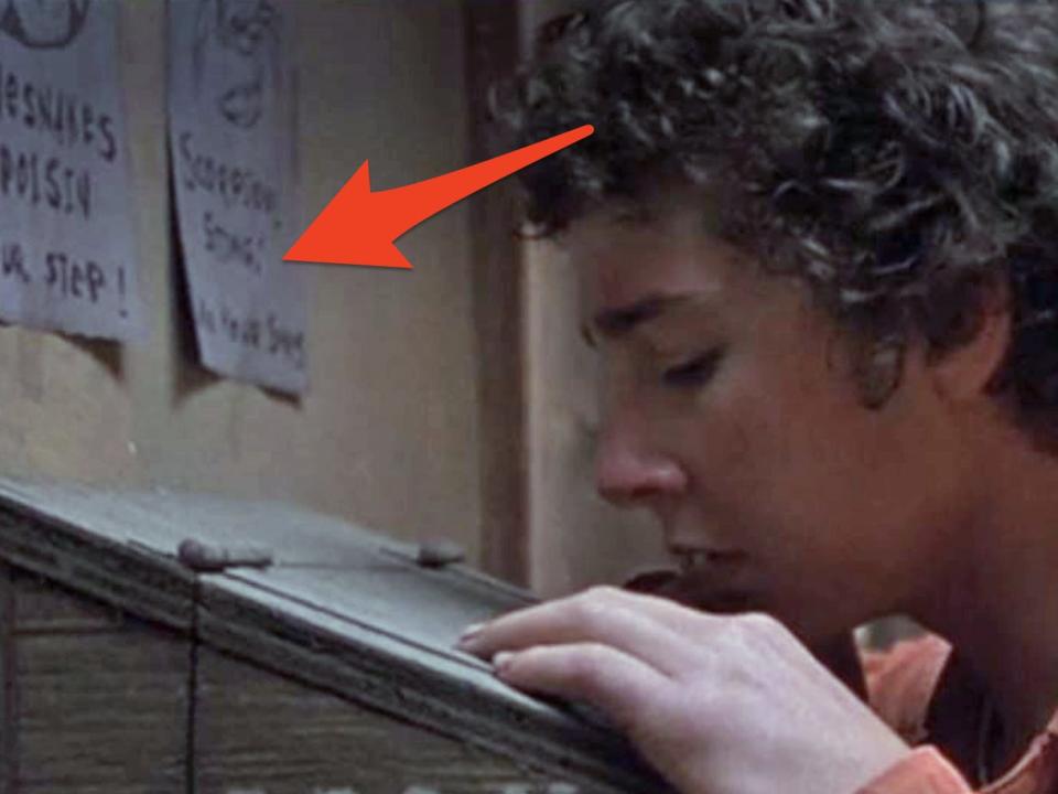 arrow pointing at scorpion warning sign behind stanley in a scene from holes