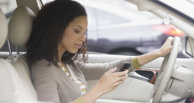 Woman checking phone in car