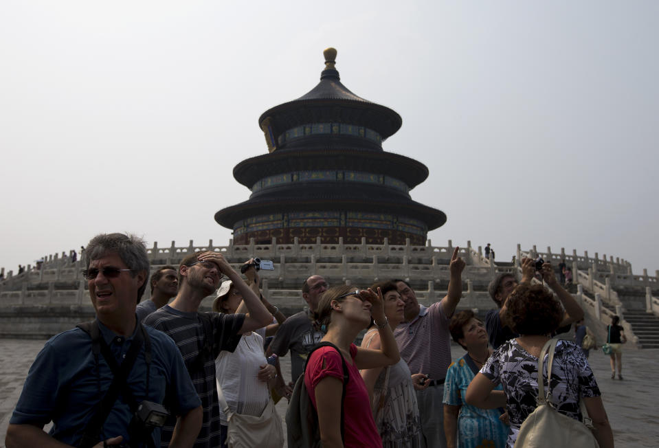 In this Wednesday, July 31, 2013 photo, a group of foreign tourists visit the Temple of Heaven in Beijing. China’s tourism industry has grown at a fast pace since the country began free market-style economic reforms three decades ago. However, it's latest tourism slogan "Beautiful China" has been derided as particularly inept at a time when record-busting smog has drawn attention to the environmental and health costs of China’s unfettered industrialization. Some point to unsophisticated marketing as an explanation. (AP Photo/Andy Wong)