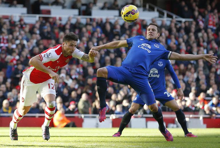 Arsenal's Olivier Giroud (L) heads under pressure against Everton on March 1, 2015