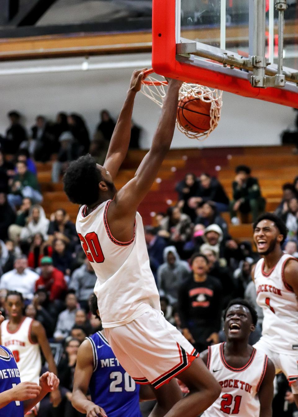 Brockton's Chidi Nwosu dunks the ball as teammates John Francois (No. 21) and Cam Monteiro, far right, celebrate during a game against Methuen in the Round of 32 of the Div. 1 state tournament on Thursday, March 2, 2023.