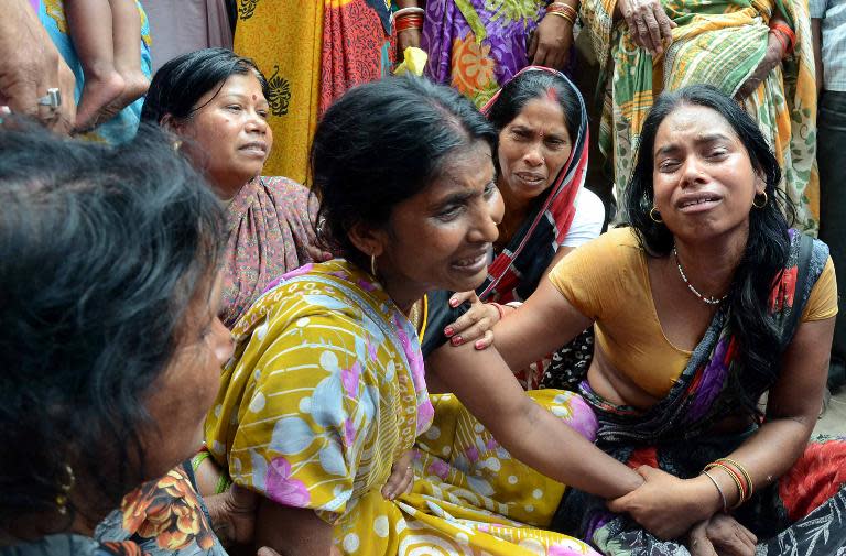 An Indian woman (C) is comforted by relatives and friends after the death of her husband on the outskirts of Patna on May 12, 2015, after a new 7.3 earthquake hit devastated Nepal