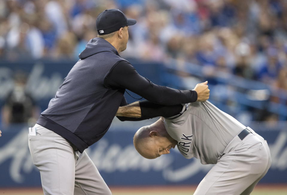 New York Yankees manager Aaron Boone holds Brett Gardner back from getting at home plate umpire Chris Segal after a called third strike during the fourth inning of the team's baseball game against the Toronto Blue Jays on Friday, Aug. 9, 2019, in Toronto. (Fred Thornhill/The Canadian Press via AP)