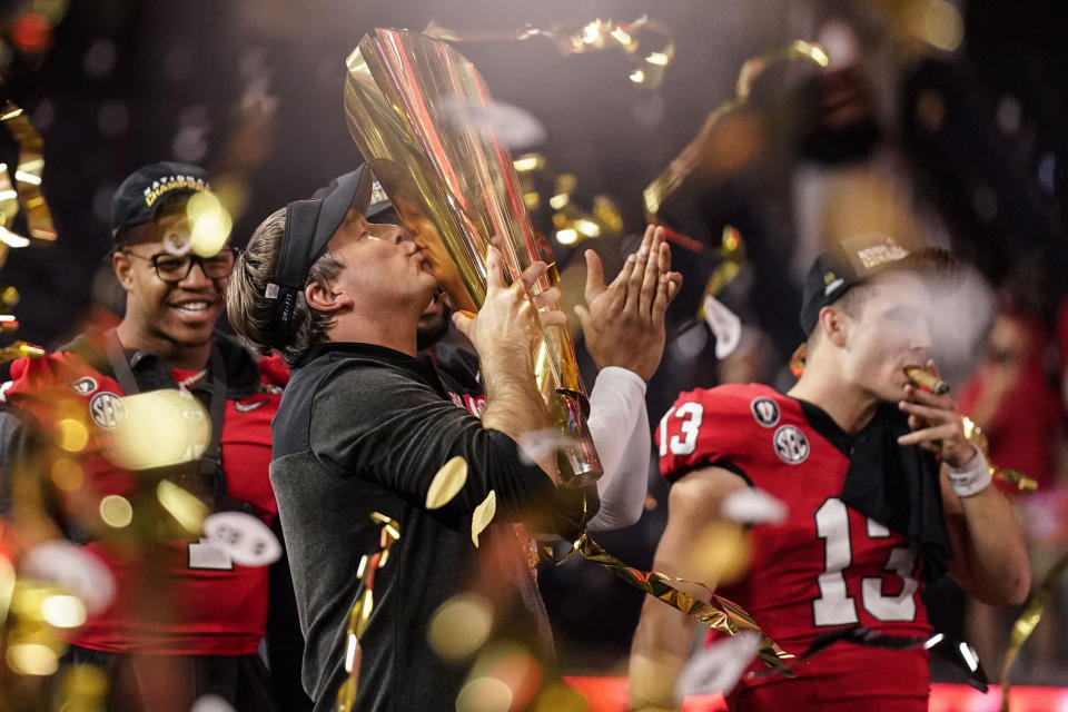 FILE - Georgia head coach Kirby Smart kisses the championship trophy after the national championship NCAA College Football Playoff game against TCU, Monday, Jan. 9, 2023, in Inglewood, Calif. As Georgia begins its quest for an unprecedented three-peat in college football, those who have been there before can provide some helpful perspective on what it takes to keep winning titles year after year after year. (AP Photo/Ashley Landis, File)