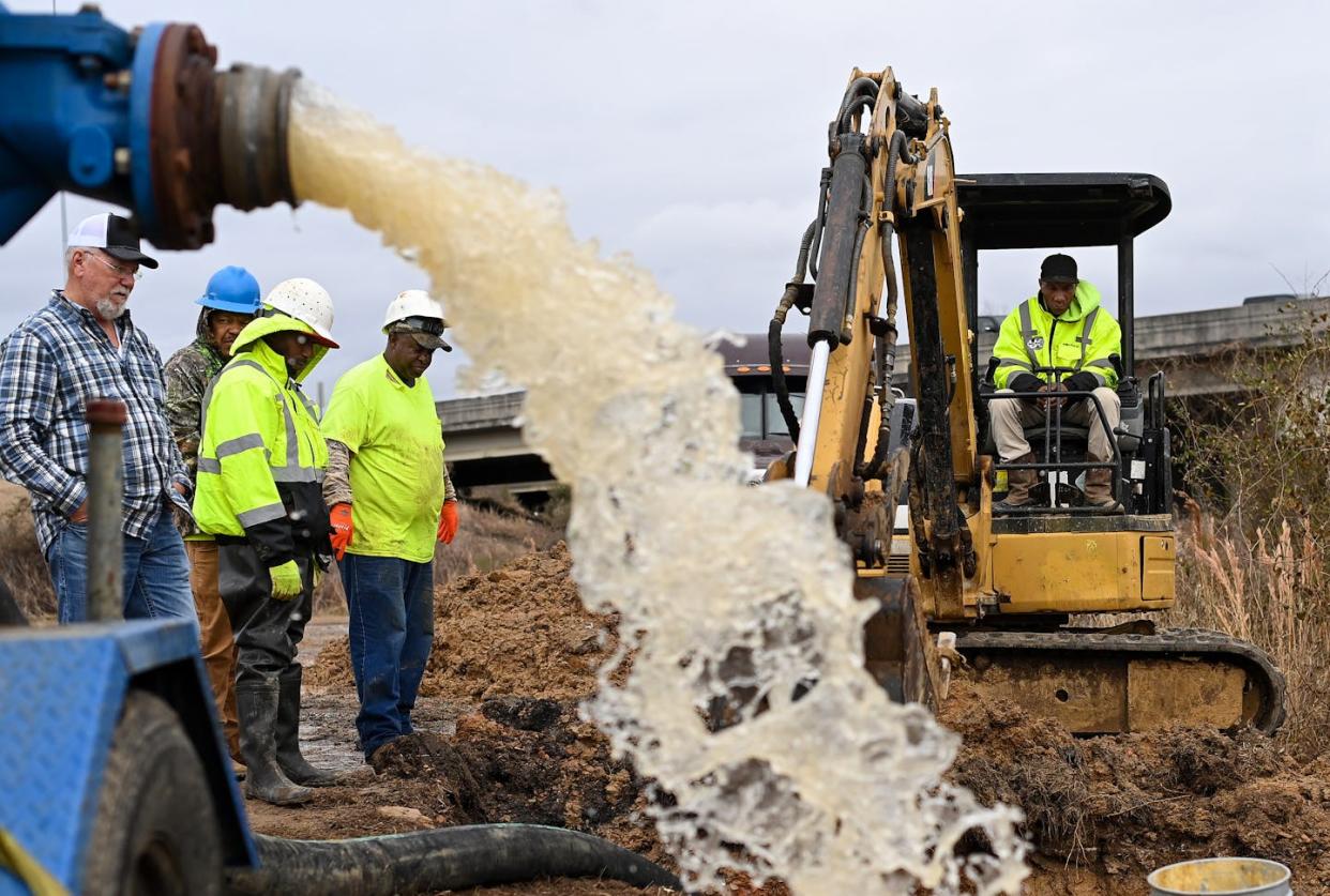 Workers attempt to repair a water main break in Jackson, Miss. <a href="https://www.gettyimages.com/detail/news-photo/water-is-redirected-from-a-damaged-water-main-break-along-news-photo/1247284588?adppopup=true" rel="nofollow noopener" target="_blank" data-ylk="slk:Joshua Lott/The Washington Post via Getty Images;elm:context_link;itc:0;sec:content-canvas" class="link ">Joshua Lott/The Washington Post via Getty Images</a>