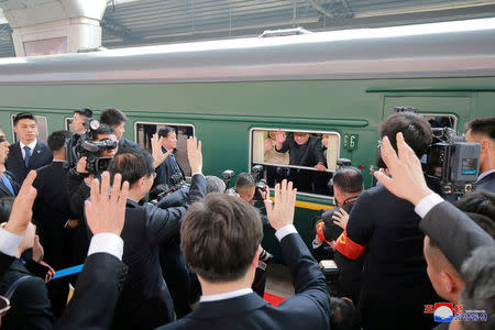 FILE PHOTO: North Korean leader Kim Jong Un waves from a train, as he paid an unofficial visit to China, in this undated photo released by North Korea's Korean Central News Agency (KCNA) in Pyongyang March 28, 2018. KCNA/via Reuters/File Photo