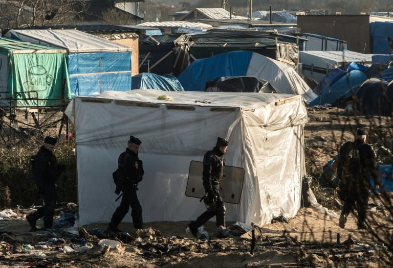 Riot police patrol in the migrant camp in Calais known as "The Jungle" on January 20, 2016